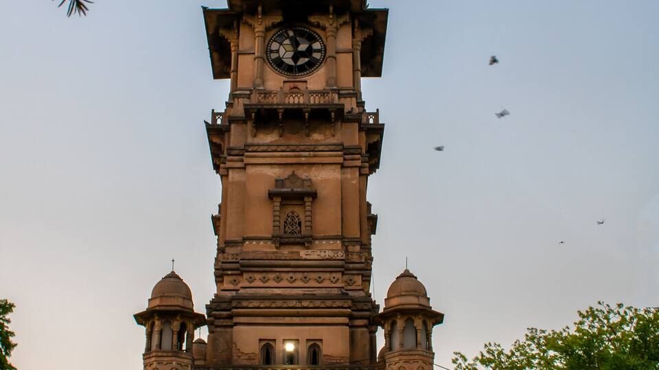 A historic clock tower with intricate architectural details and a dome on top.