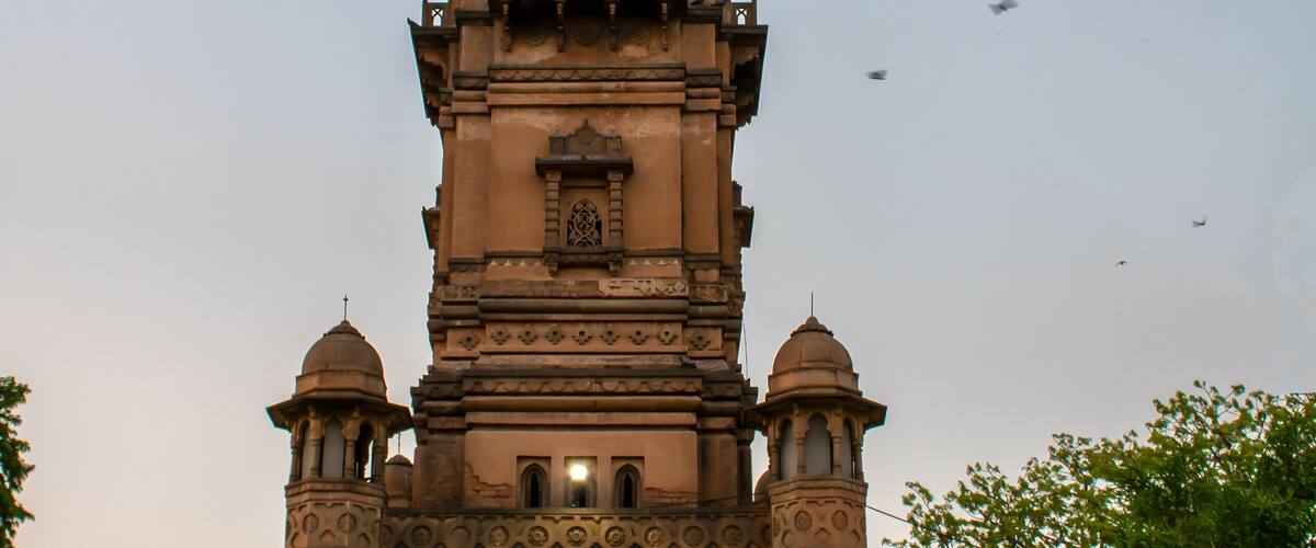 A historic clock tower with intricate architectural details and a dome on top.