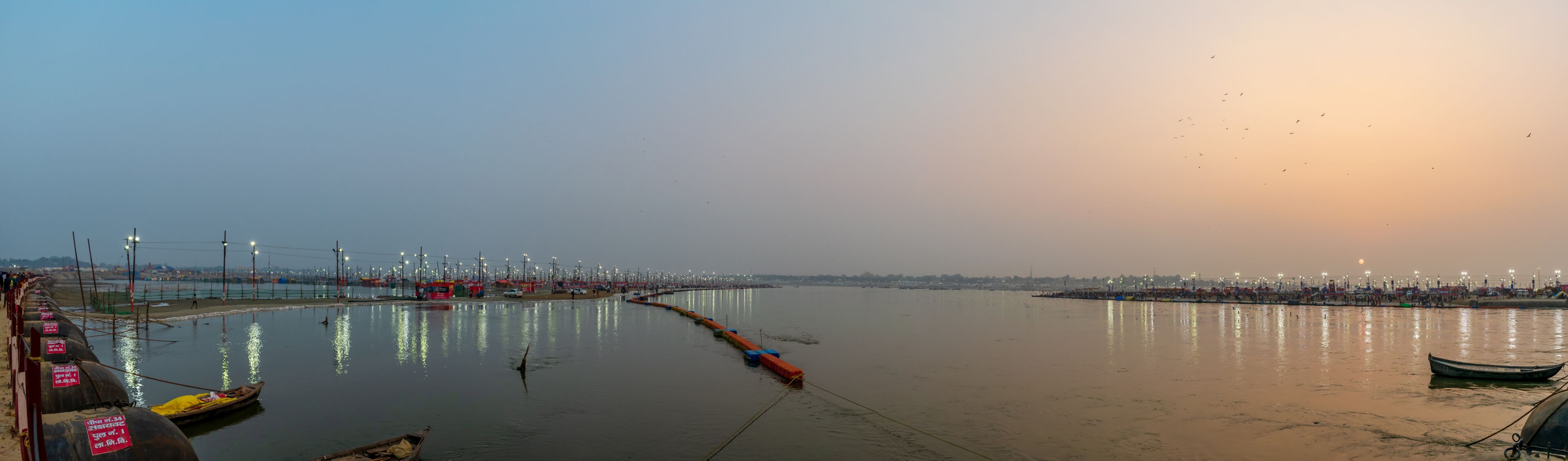 A river with boats, a bridge, and a cityscape in the background.