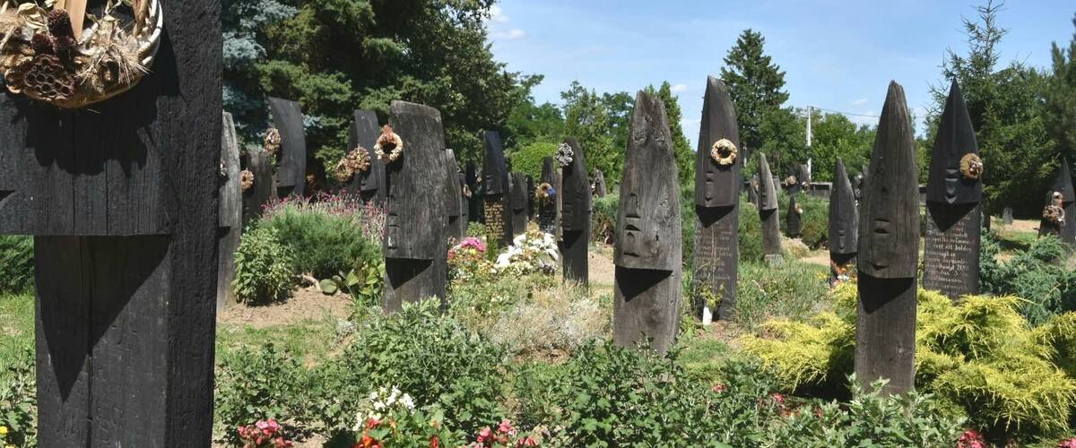 A cemetery with unique, pointed headstones and a wicker basket with a skull decoration.