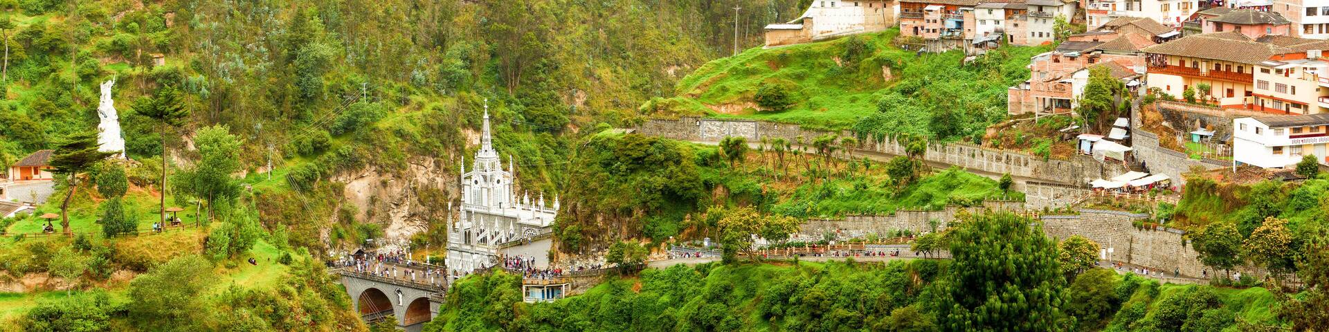 Un paisaje verde y exuberante con una iglesia blanca y un puente de piedra.