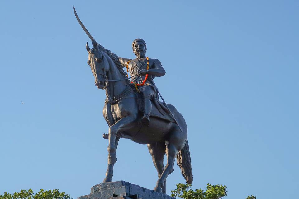 Une statue représentant une personne à cheval, vêtue d’une tenue traditionnelle et d’un turban, et tenant une épée levée.