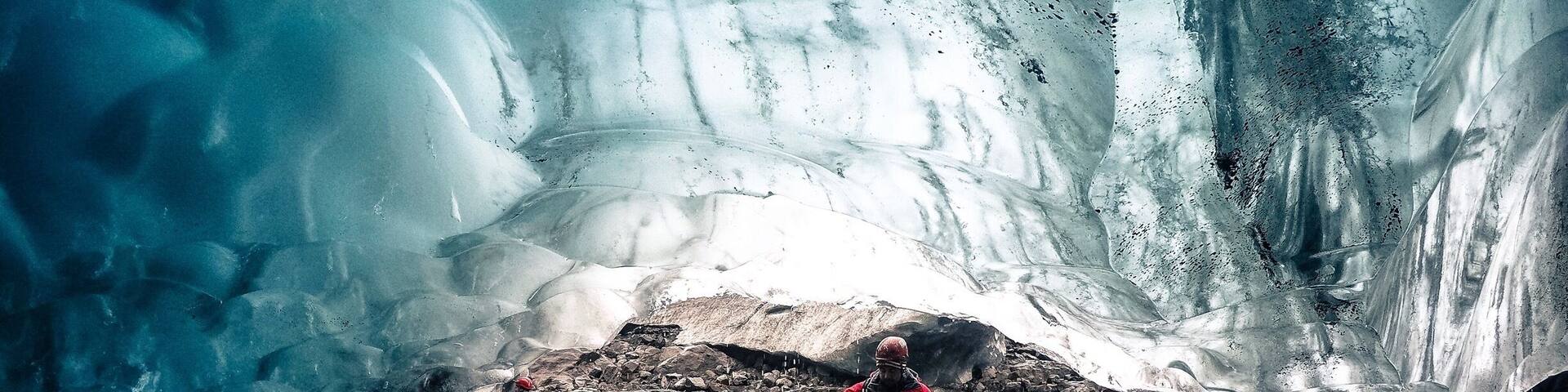 A glacier with people standing on a wooden platform.