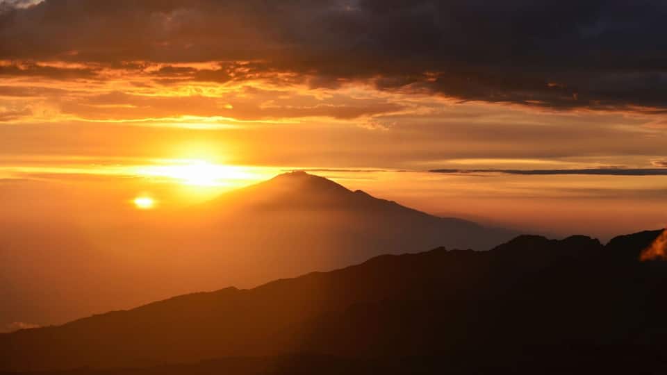 beautiful sunset on the kilimanjaro with a view of mount meru in tanzania shira camp. Hike to the highest mountain afirka