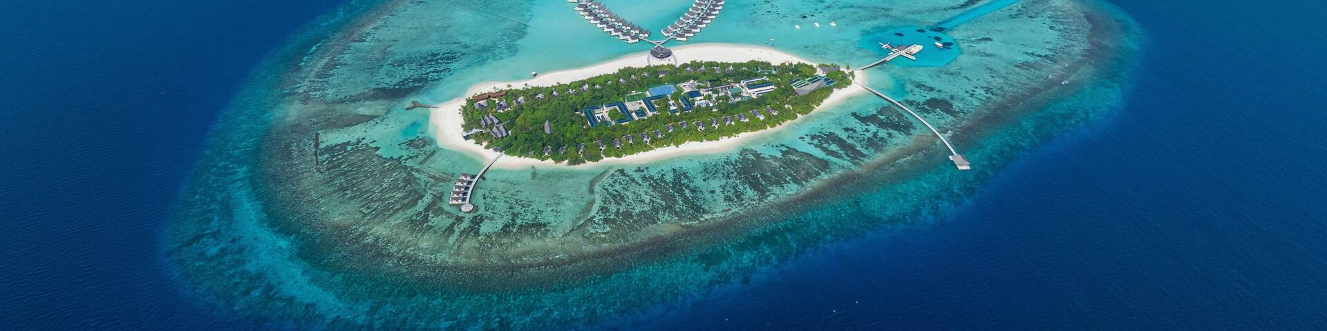 Aerial view of Kuredhivaru Island with luxury resort and beautiful turquoise beach, Noonu Atoll, Maldives.