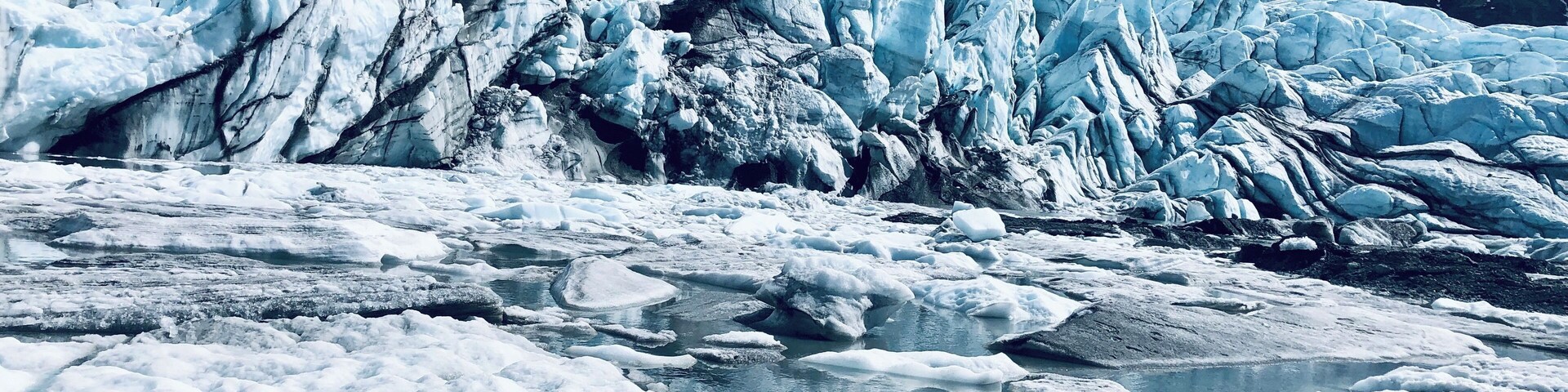 Um glaciar com formações de gelo e um rio.
