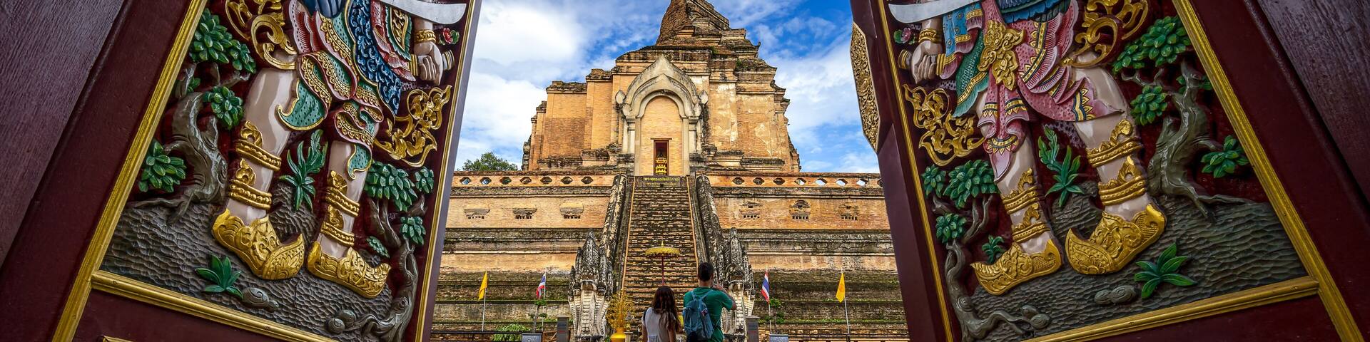 CHIANG MAI , THAILAND- AUGUST 23, 2019 : Tourist Asian Couple Traveling Backpackers looking old pagoda while traveling around Thai temple on holidays in Chaing Mai, Thailand