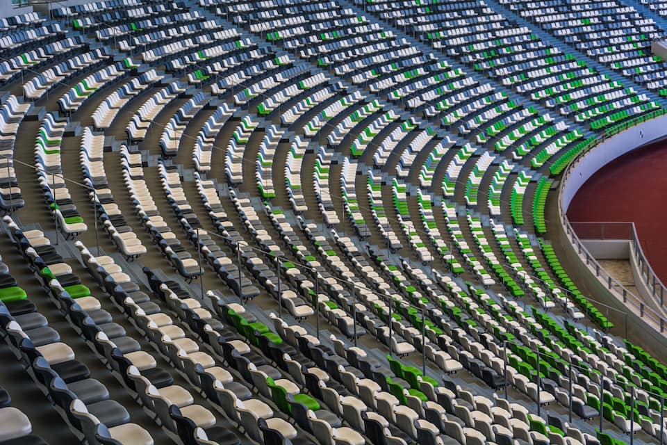 A stadium with rows of seats, some green and some white.