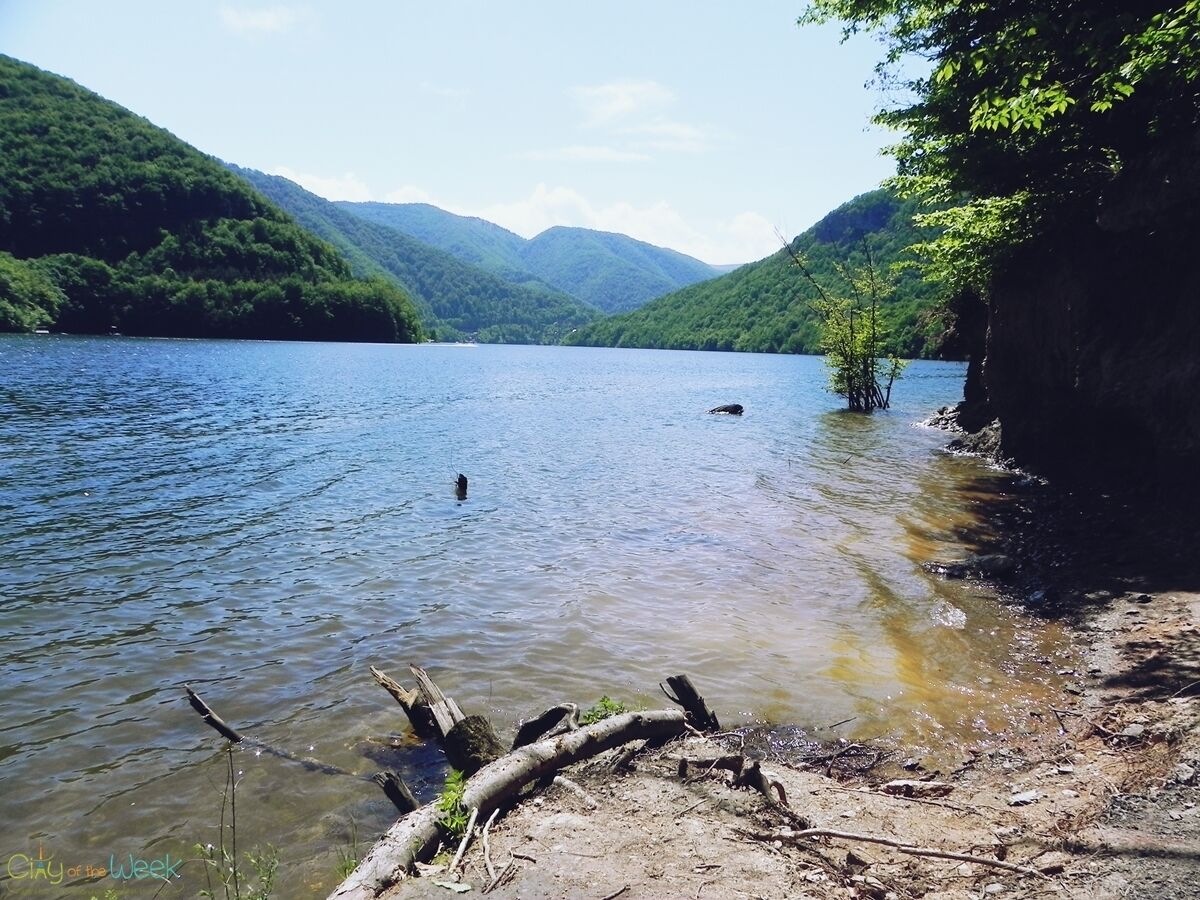 A calm lake surrounded by lush green hills.