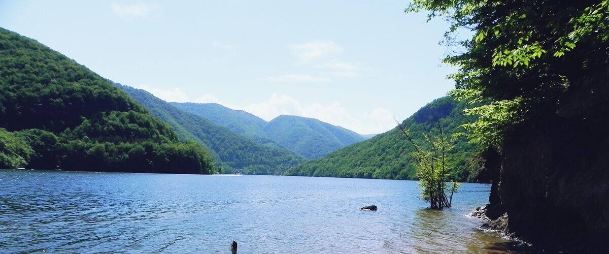 A calm lake surrounded by lush green hills.