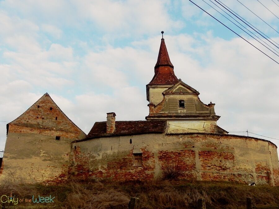A historic building with a pointed roof and a smaller structure with a gabled roof.