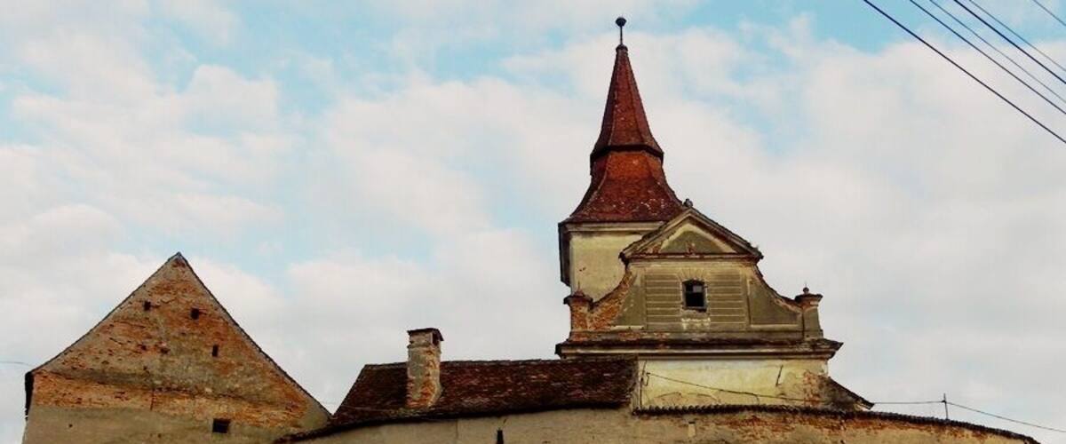 A historic building with a pointed roof and a smaller structure with a gabled roof.