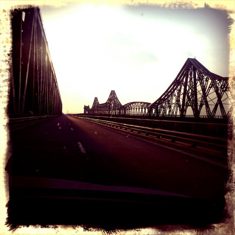 A bridge with multiple trusses and a clear sky.