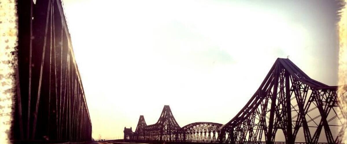 A bridge with multiple trusses and a clear sky.