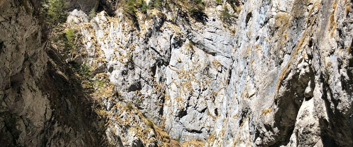 A winding mountain road flanked by rocky cliffs and sparse vegetation.