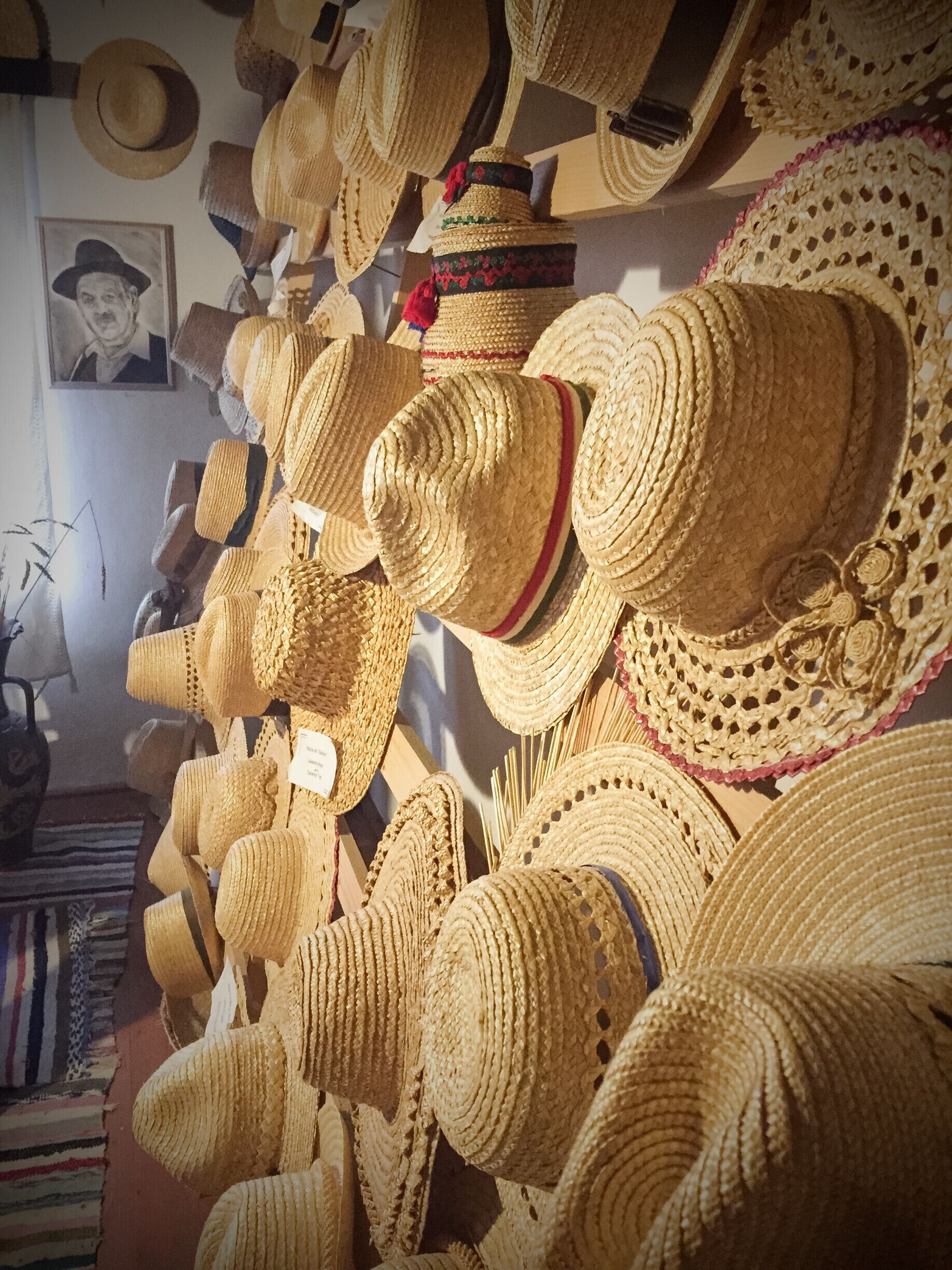 A variety of woven hats displayed on shelves.