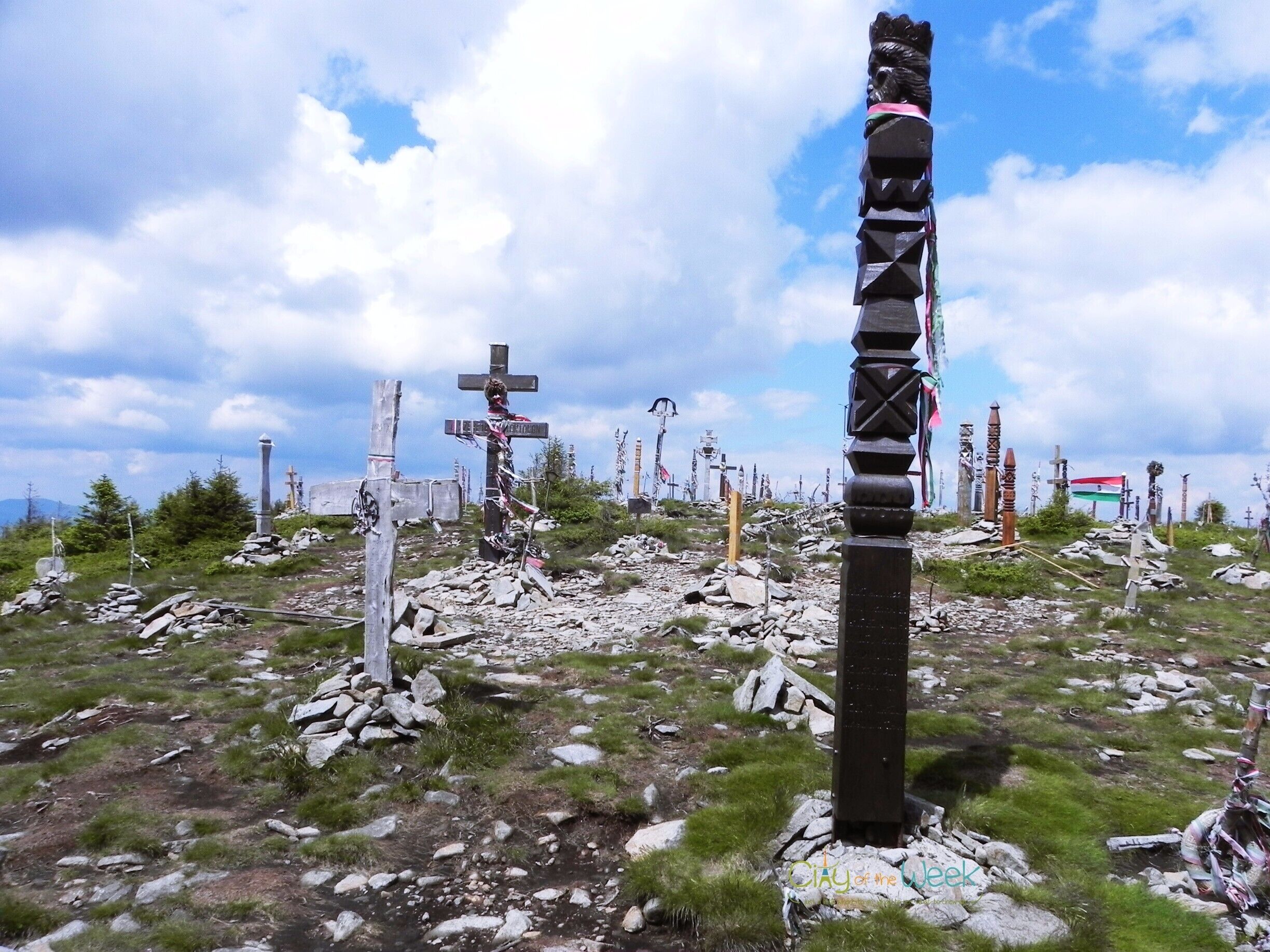 A cemetery with numerous crosses and a prominent totem pole.