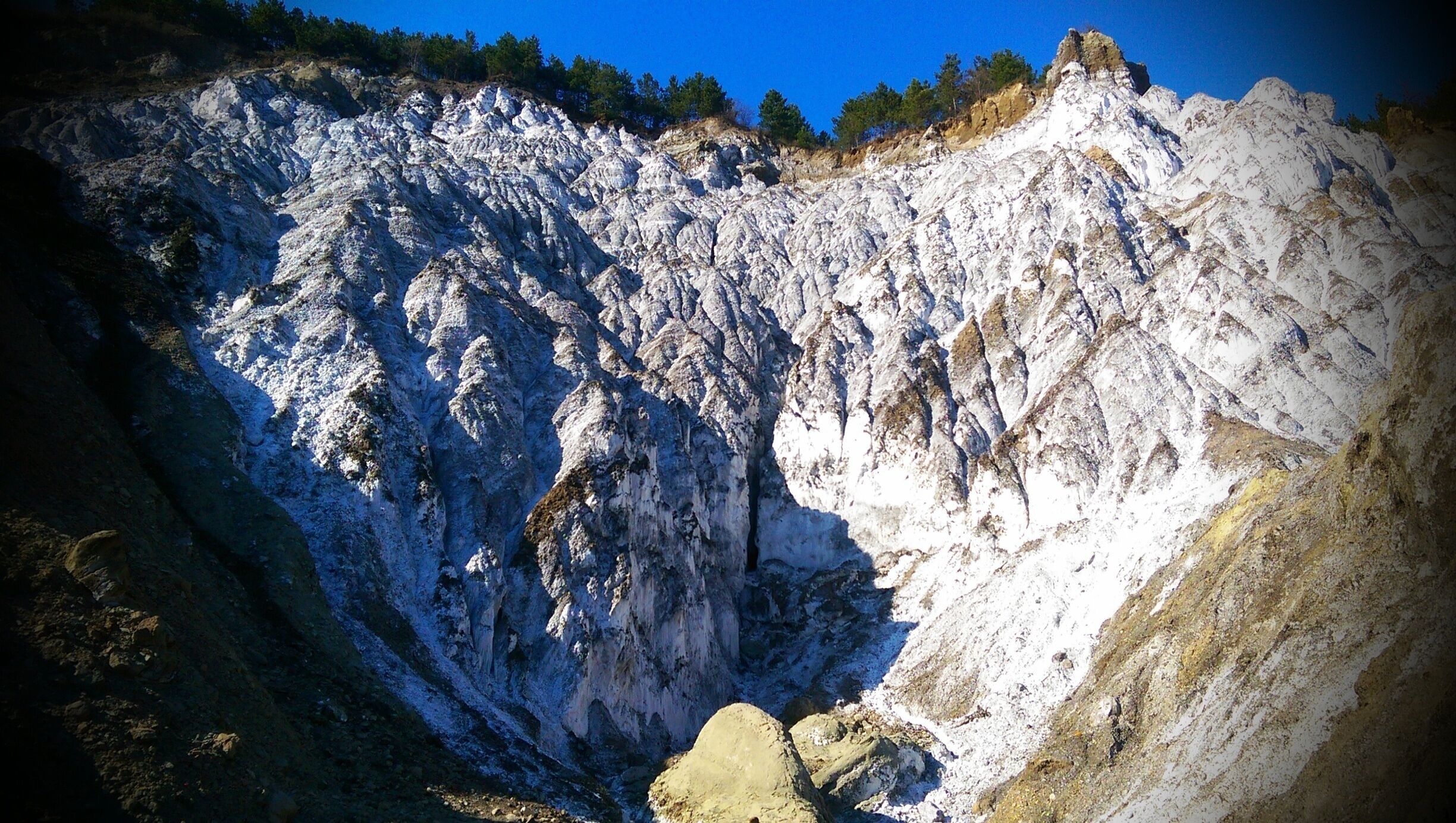 A rugged mountain landscape with steep cliffs and sparse vegetation.