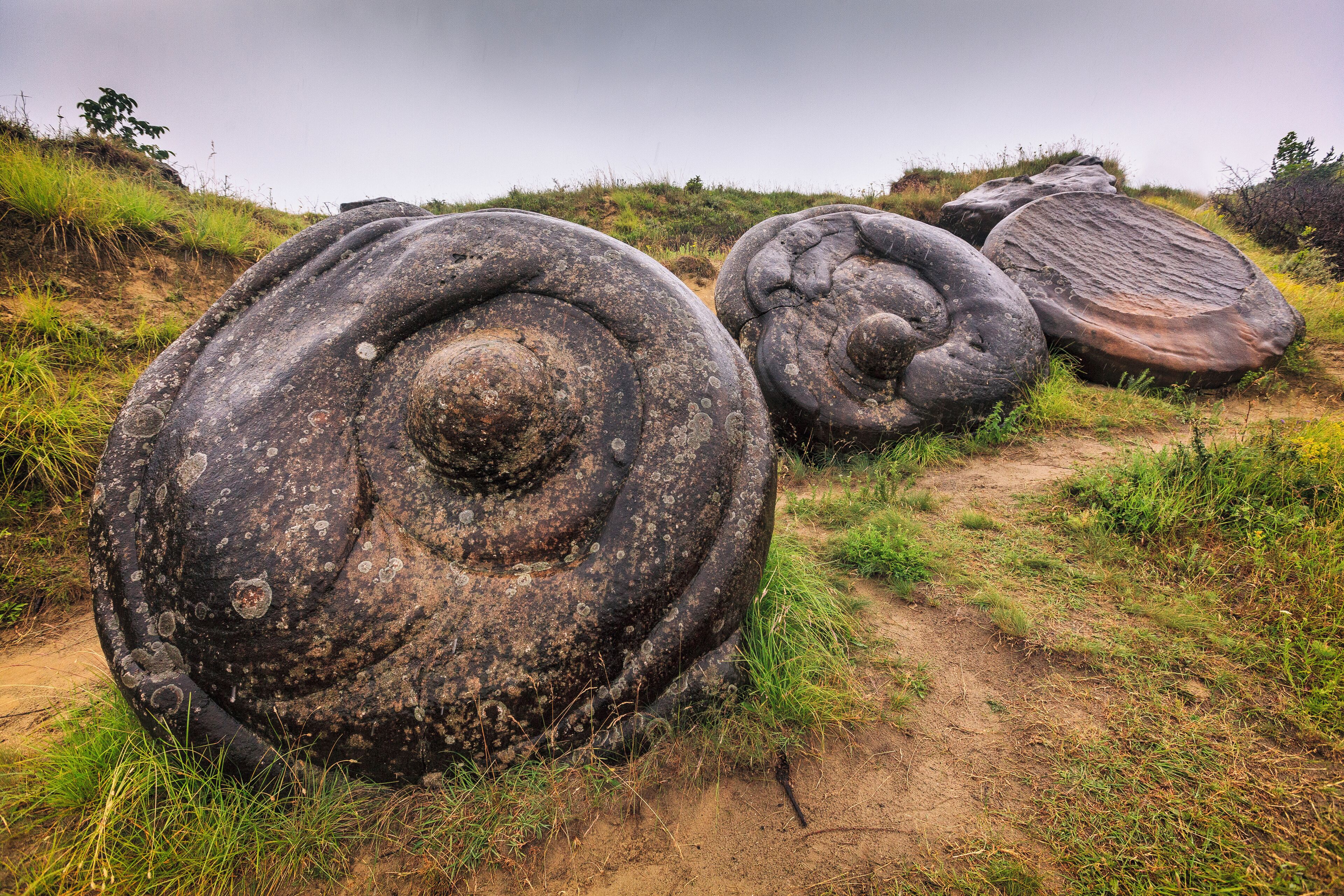 Large spiral rock formations in a grassy area.