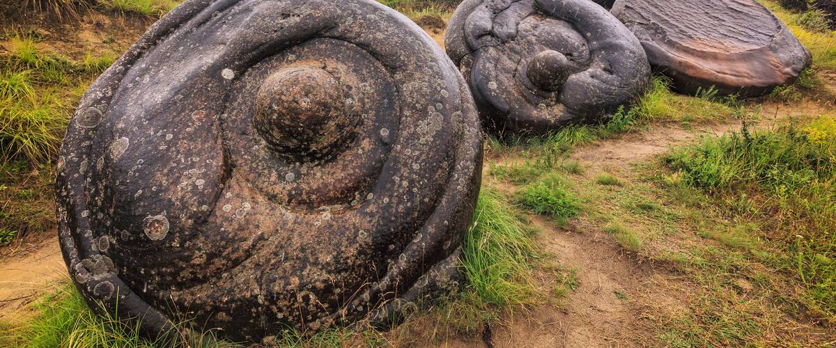 Large spiral rock formations in a grassy area.