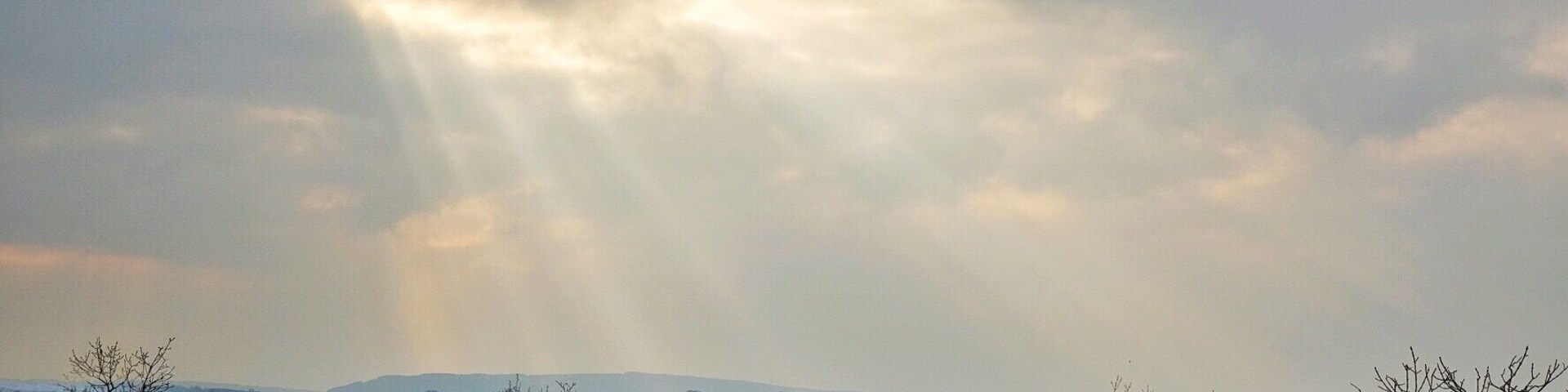 Un paisaje rocoso con poca vegetación y un cielo nublado.