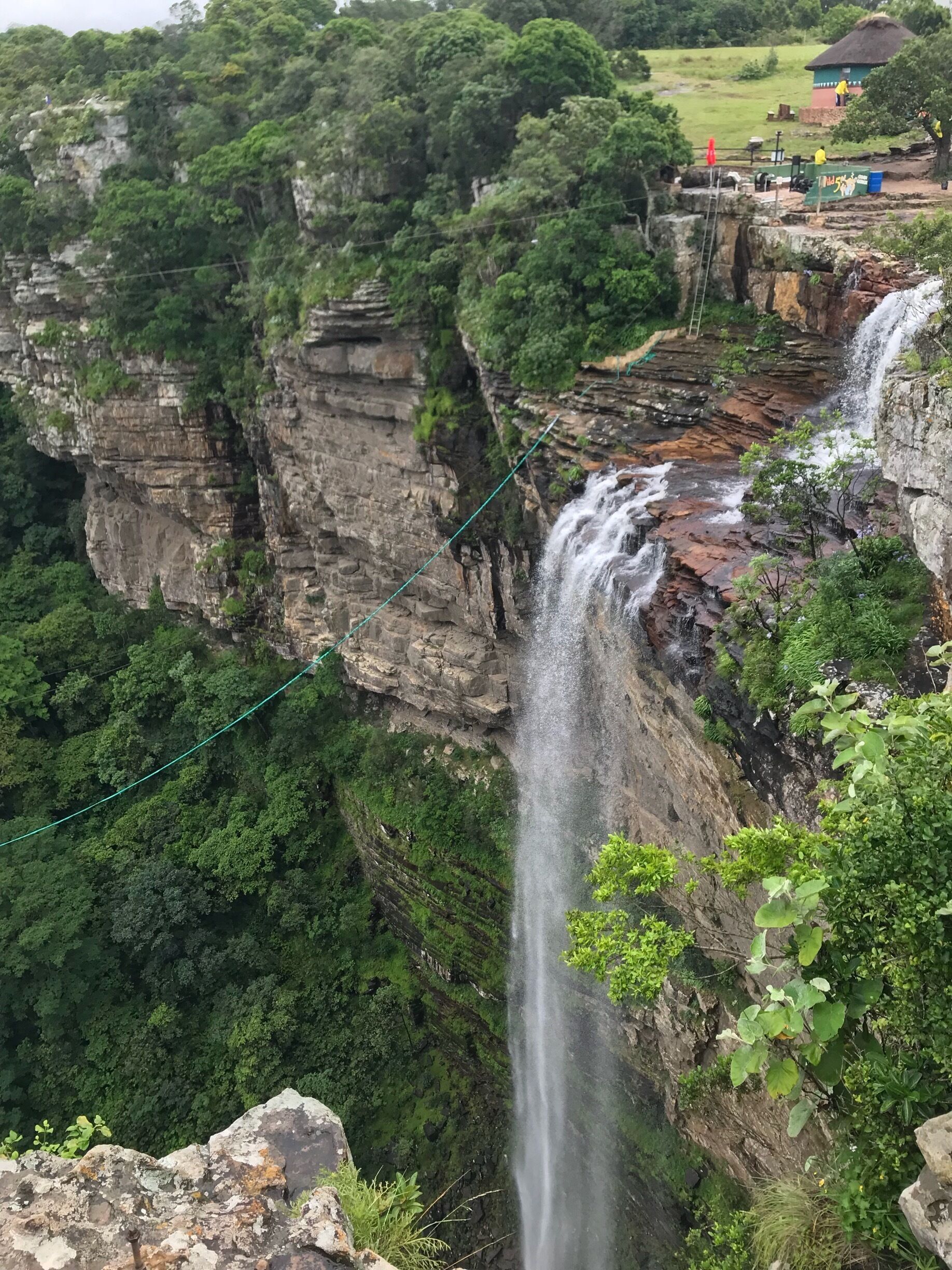 A torrent of water from a river pours in to the Oribi Gorge while adventurists wait to get harnessed for a gravity defining dive into the abyss. #river