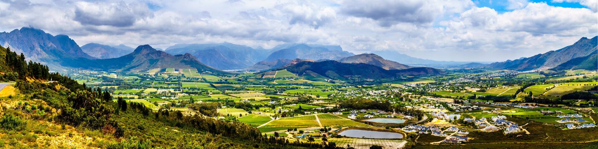 Panorama view of the Franschhoek Valley in the Western Cape of South Africa with its many vineyards in the Cape Winelands, surrounded by the Drakenstein mountain range, as seen from Franschhoek Pass