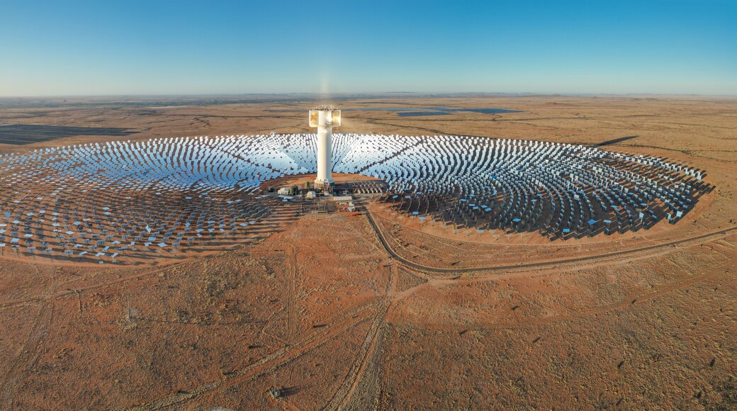Expansive array of mirrors surround Khi Solar One concentrated solar tower in dry desert landscape of South Africa