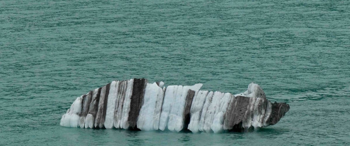 A large iceberg floating in calm water.