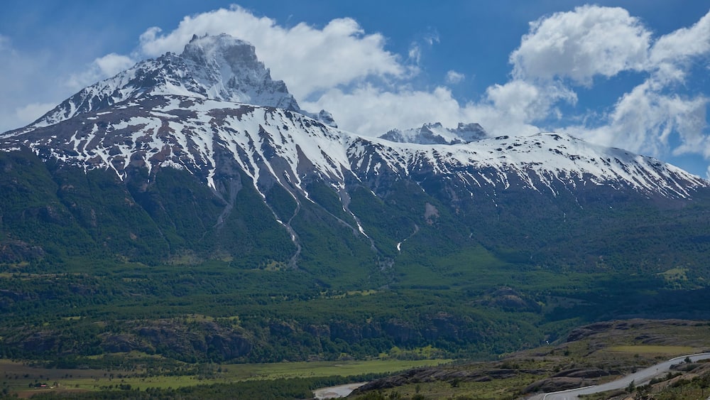 A snow-capped mountain range with a river flowing through a valley.