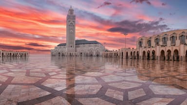 Uma mesquita com um minarete alto e um amplo pátio com azulejos padronizados.