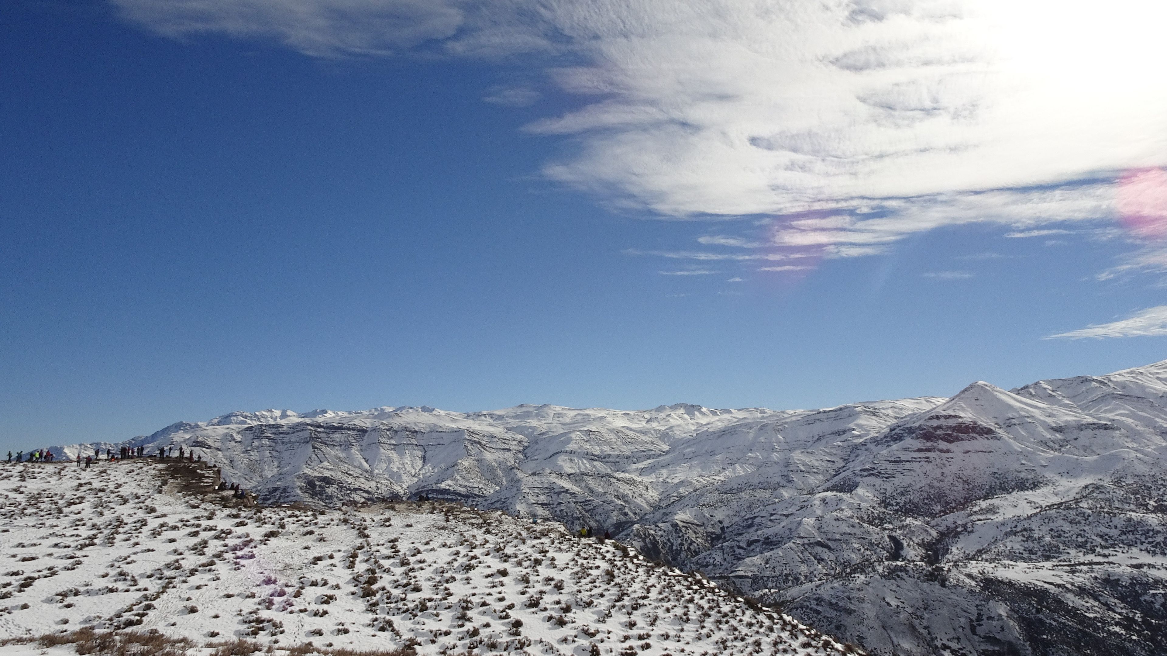 Una cordillera nevada con cielo despejado y algunas nubes.