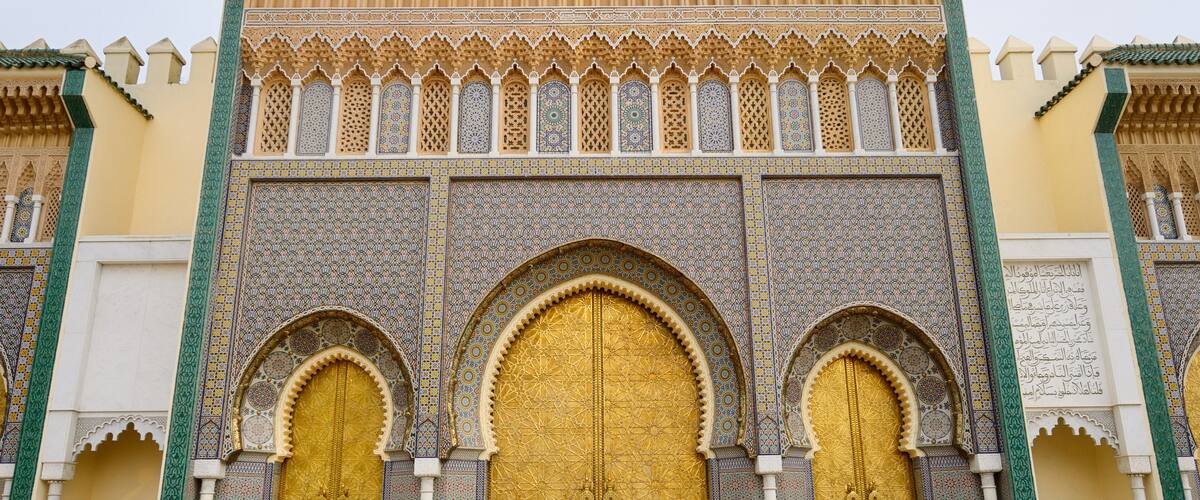 A large ornate gate with intricate tile work and a golden door.