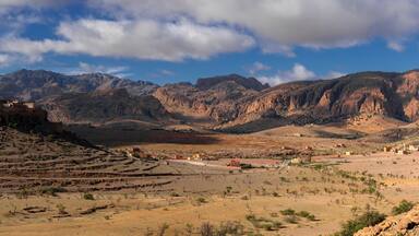 panorama landscape view of the Altas mountains in Morocco with the Kasbah Tizourgane on the hilltop in the centre