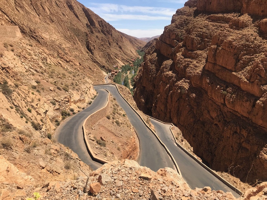 Road leading down into Dades Gorge where an oasis of plants, a Berber village and water live between beautiful sandstone mountains. #dadesgorge #morocco #africa #berber #earthbound #travel #slowtravel #travelmorocco #mountains #sandstonemountains #moroccanmountains #roadtrip #ilovemorocco #flashpackingbarbie