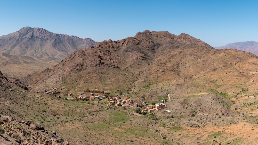 A rugged mountainous landscape with a small village nestled in a valley.