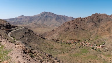 Un paisaje montañoso agreste con un pequeño pueblo enclavado en un valle.