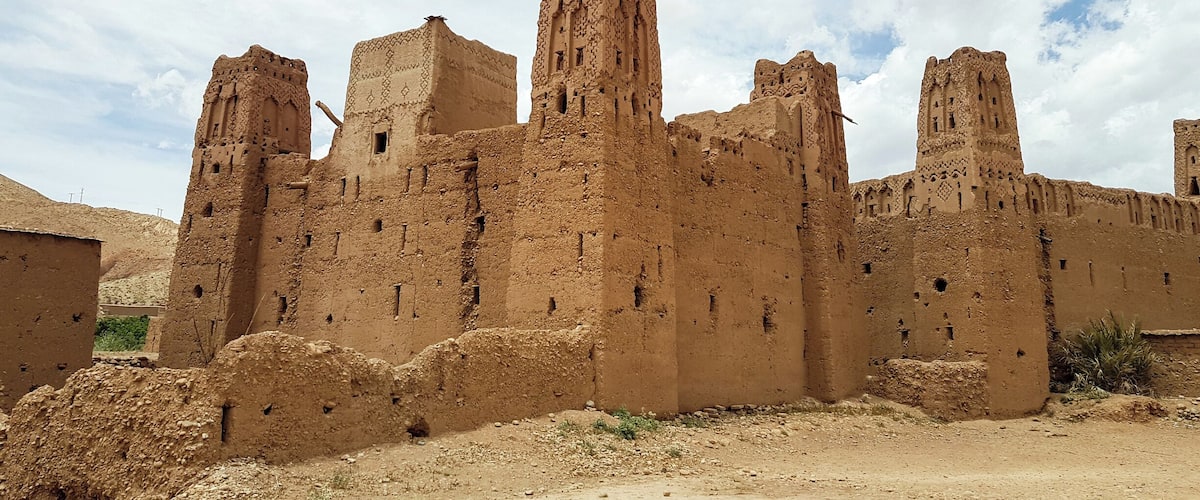 A large, ancient mud-brick fortress with multiple towers and battlements.