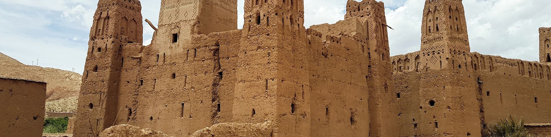A large, ancient mud-brick fortress with multiple towers and battlements.