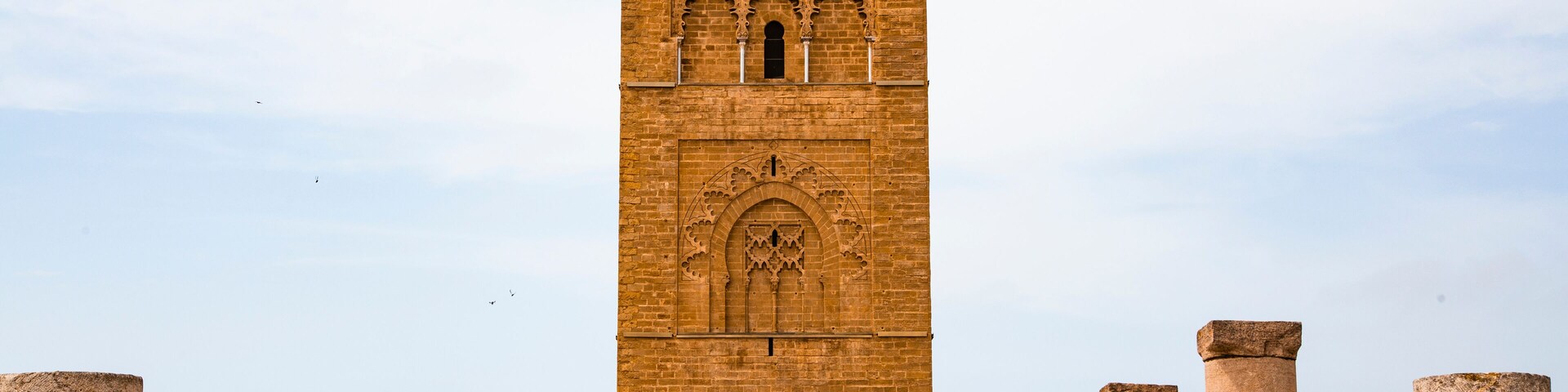 A tall, ornate tower with intricate carvings and columns at its base.