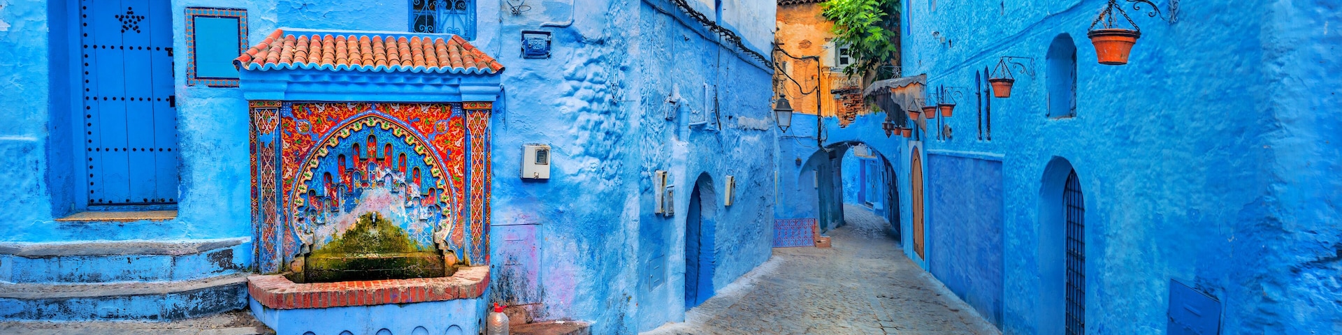 Fountain with drinking water on house coloured wall in blue town Chefchaouen. Morocco, North Africa