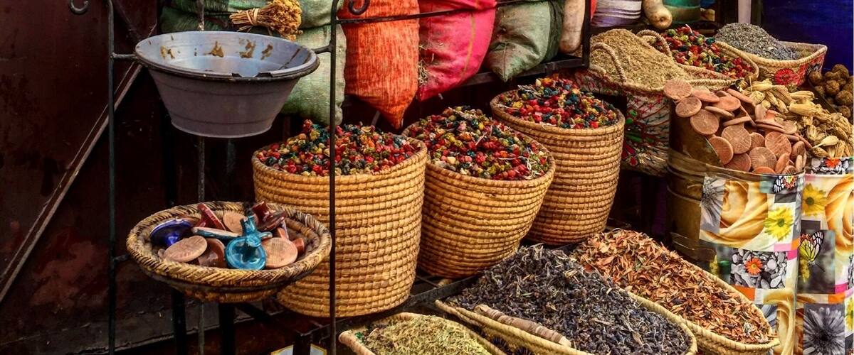 A market stall with colorful bags of spices and herbs.