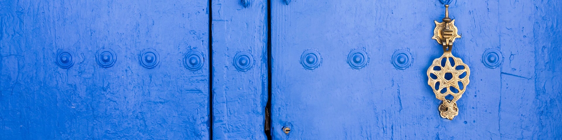 Background of traditional powder blue painted door with golde doorknocker
