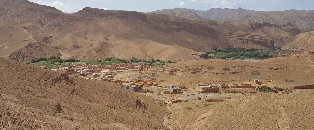 A mountainous landscape with a village nestled in a valley.
