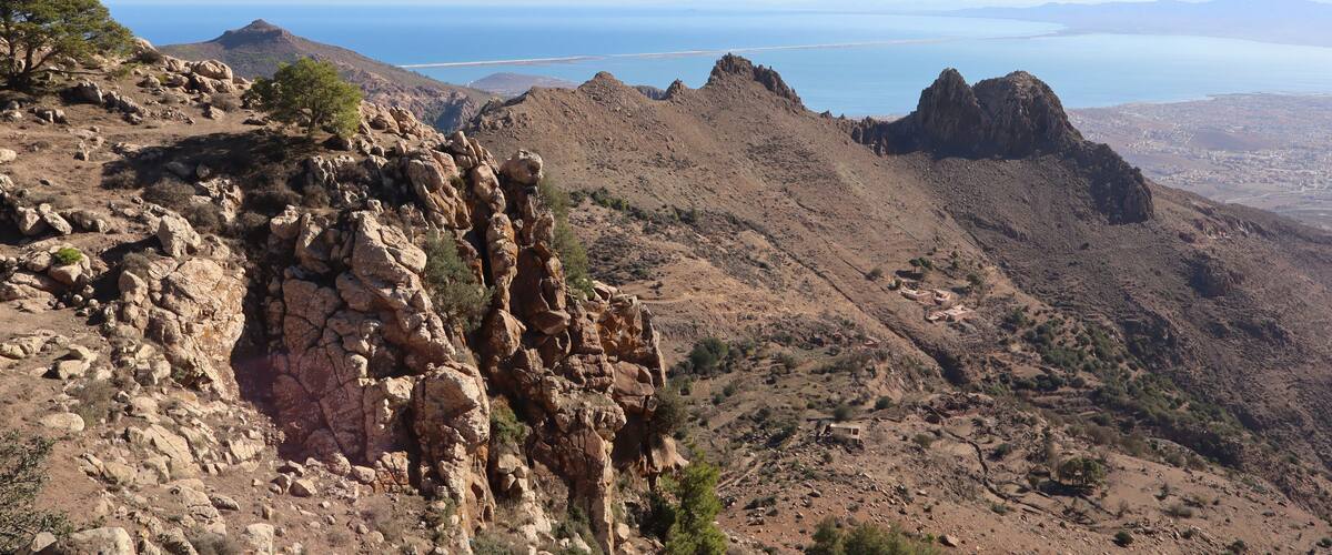 A rugged mountain landscape with rocky outcrops and sparse vegetation.