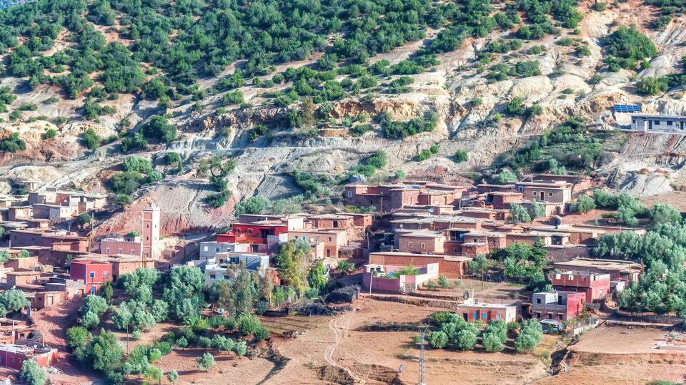 A hillside village with terraced houses and sparse vegetation.