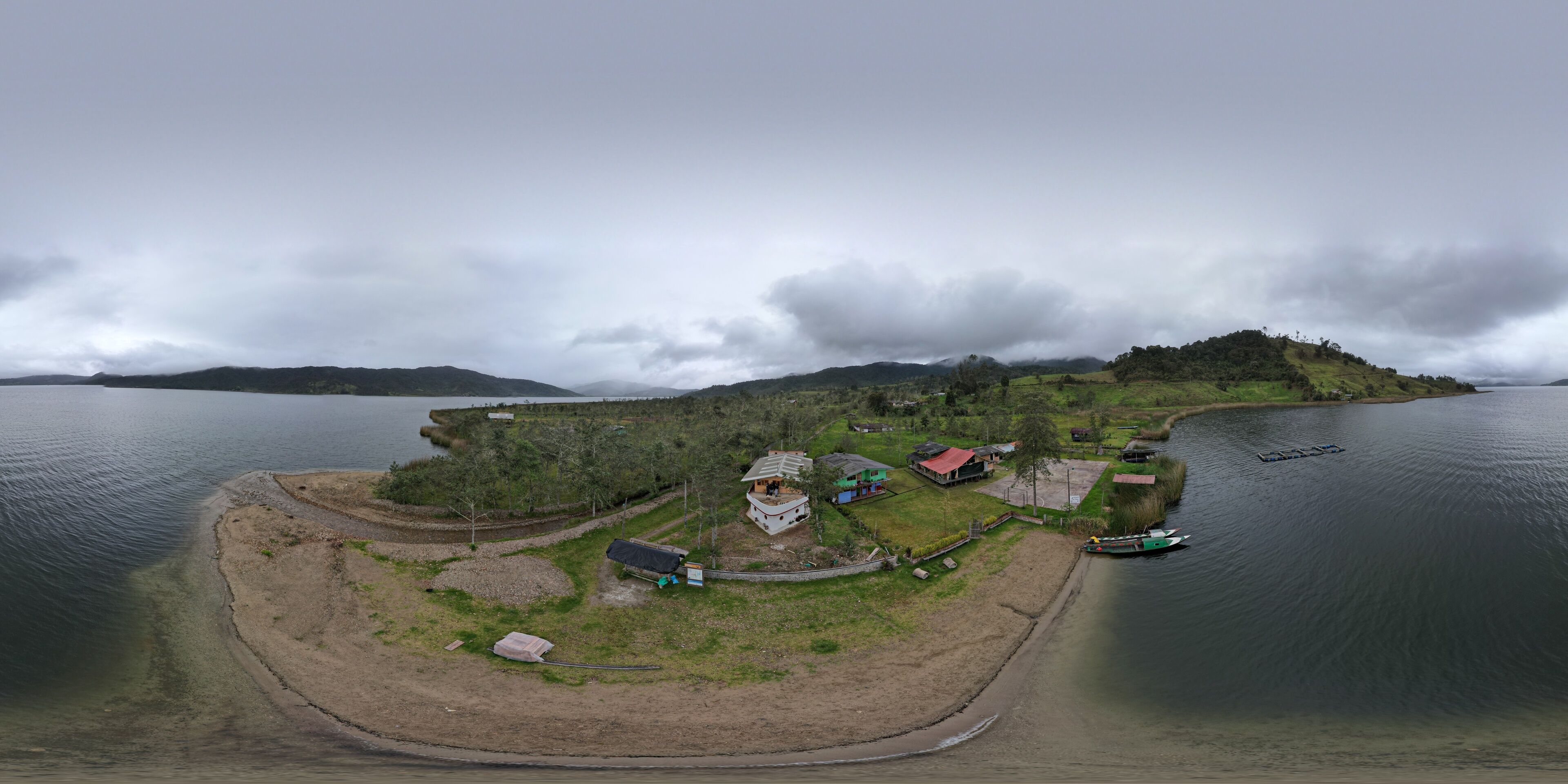 A coastal village with houses, a dock, and a small island in the background.