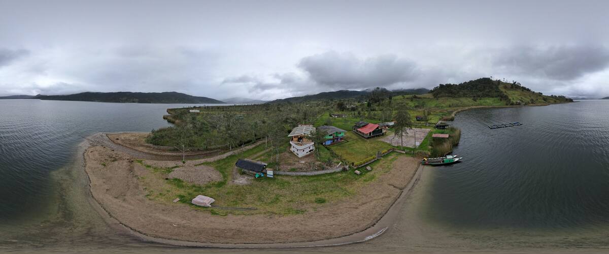 A coastal village with houses, a dock, and a small island in the background.