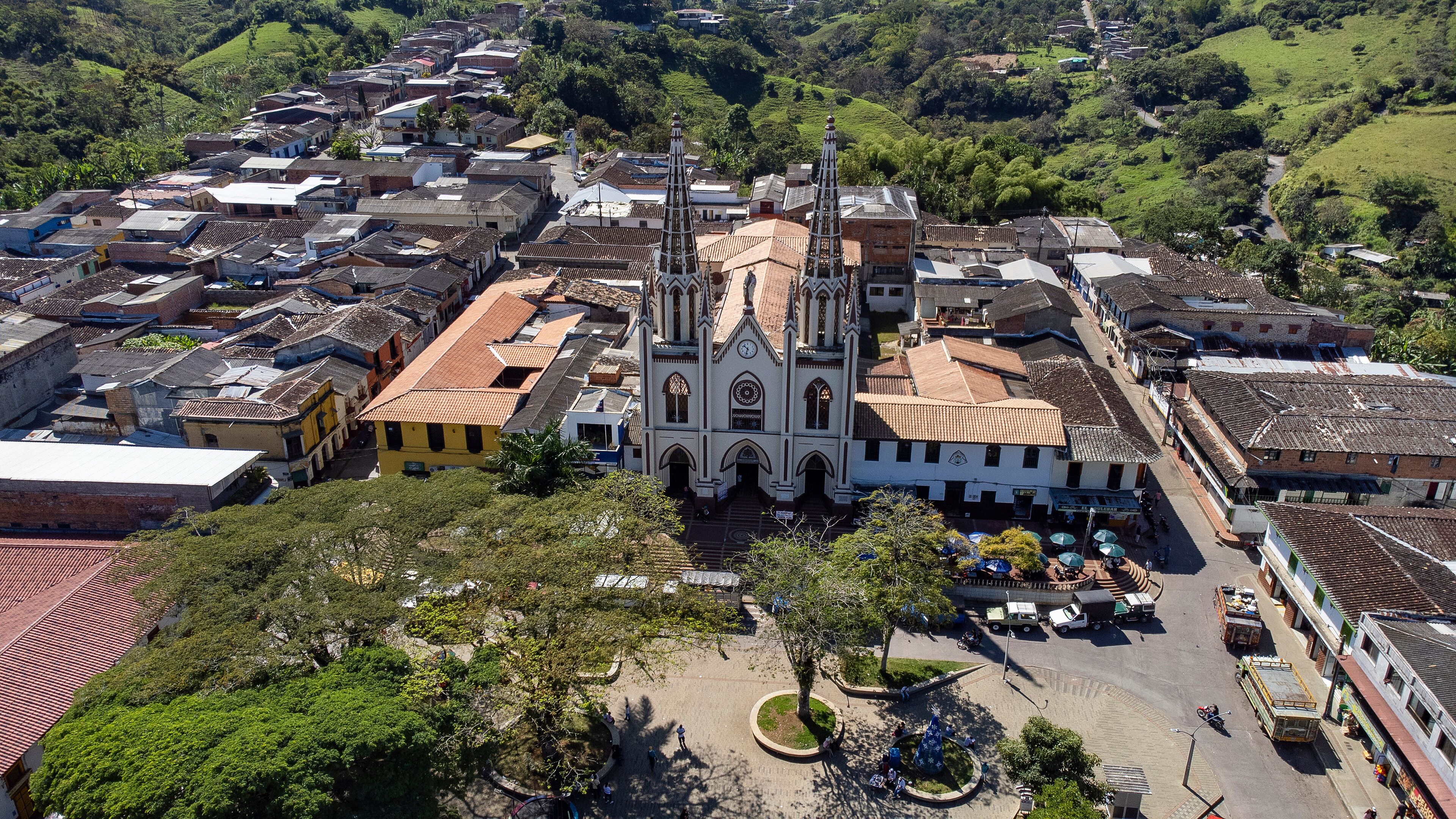 A historic town with a prominent church featuring two tall spires, surrounded by traditional buildings and lush greenery.