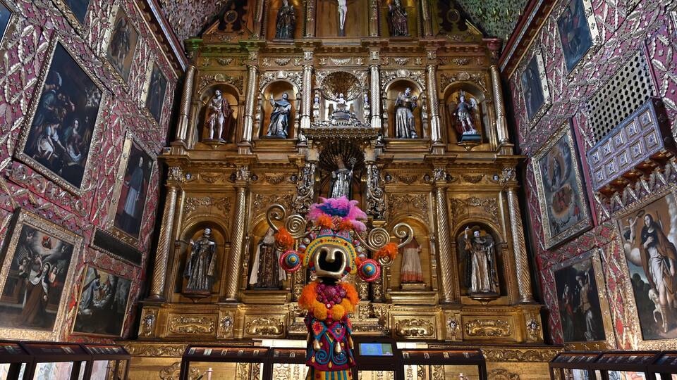 A richly decorated altar with religious statues and paintings.